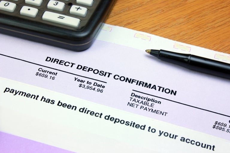 Direct deposit confirmation notice on a desk with a calculator showing money deposited into account